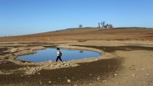A visitor walks near the receding waters at Folsom Lake, which is 17 percent of its capacity, in Folsom, California January 22, 2014. California Governor Jerry Brown last week declared a drought emergency, and the dry year of 2013 has left fresh water reservoirs with a fraction of their normal water reserves. Picture taken January 22, 2014. REUTERS/Robert Galbraith (UNITED STATES - Tags: ENVIRONMENT TPX IMAGES OF THE DAY) - RTX17T4L