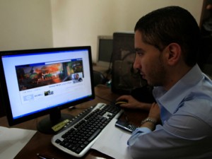 A Palestinian man looks at the Facebook page of Avichay Adraee, the spokesman of the Israeli Army to the Arabic media, after hackers replaced his cover photo with that of the Ezzedine al-Qassam Brigade during the "#Op_Israel" campaign launched by the activist group Anonymous, in Gaza City on April 7, 2013. The hackers reportedly hit several Israeli websites including that of the premier's office, the defence ministry, the education ministry and the Central Bureau of Statistics, among others, but all appeared to be running normally. AFP PHOTO/ SAID KHATIB.. PALESTINIAN-ISRAEL-INTERNET-IT-SECURITY-HACKING