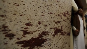 Members of the Ismaili community stand near a blood-stained wall at the site of a car bomb attack outside an Ismaili mosque in Yemen's capital Sanaa July 29, 2015. A car bomb exploded outside an Ismaili mosque in Yemen's war-damaged capital Sanaa on Wednesday, killing four people and wounding six, health authorities and a security source said. The Islamic State militant group claimed responsibility for the attack on the Al Faydh Alhatemy mosque, more commonly known as Burhani, in the eastern Sanaa of Nuqum, describing the bombing as revenge for what it called Ismaili support for Yemen's dominant Houthi movement. REUTERS/Khaled Abdullah - RTX1MB77