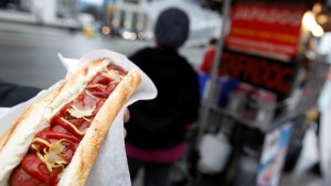 A Japadog hot dog, using Kobe beef sausage and named after Japan's figure skater Mao Asada, is held by a customer before the Vancouver 2010 Winter Olympics February 11, 2010. The pair of Japadog stands are proving popular with Japanese tourists and press attending the Olympics. The hot dog is seen garnished with yuba, dried tofu skin, cut in the shape of maple leaves. REUTERS/Chris Helgren (CANADA - Tags: SPORT OLYMPICS FOOD SOCIETY) - RTR2A4A9