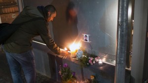A man burns a candle at the gate of the Berlin Office of Health and Social Affairs (LAGESO) for a killed boy in Berlin, Germany, October 29, 2015. Berlin police said they have arrested a 32-year-old man suspected of abducting a 4-year-old refugee earlier this month. The body of a child was found in his car. Mohamed Januzi disappeared on October 1, 2015 while waiting outside the offices of the government programme for social care (LaGeSo) with his mother and two siblings. REUTERS/Hannibal Hanschke - RTX1TUGX